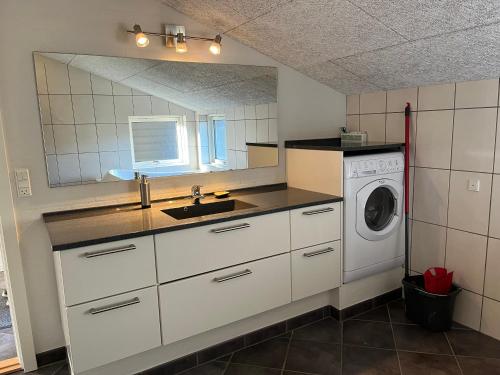 cocina con fregadero y lavadora en Hovborg Ferieby -Torpet 20, en Hovborg