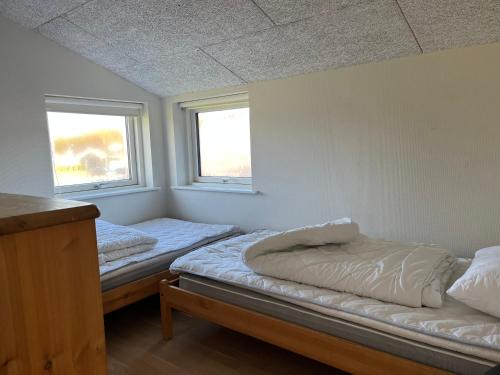 two beds in a room with two windows at Hovborg Ferieby -Torpet 20 in Hovborg