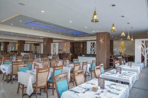 a dining room with white tables and chairs at Anastasia Waterpark Beach Resort in Protaras