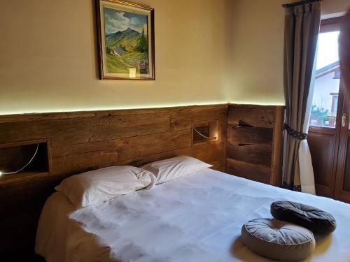 a bedroom with a bed with two pillows on it at La Vigne de Papagran in Aosta