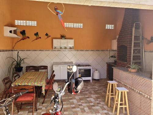 a kitchen with a table and chairs and a kite on the wall at Casa 4 quartos, com piscina no Condominio Sol Marina Jacuipe com acesso a praia e ao rio de Jacuipe in Camaçari