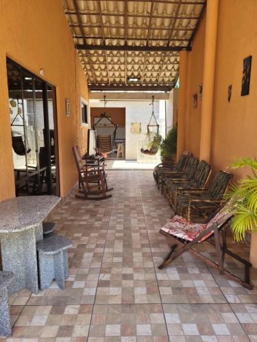 a living room with chairs and tables and a patio at Casa 4 quartos, com piscina no Condominio Sol Marina Jacuipe com acesso a praia e ao rio de Jacuipe in Camaçari