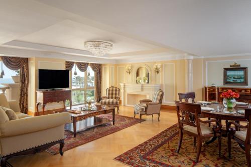 a living room with a table and a dining room at The Regency Hotel Kuwait in Kuwait