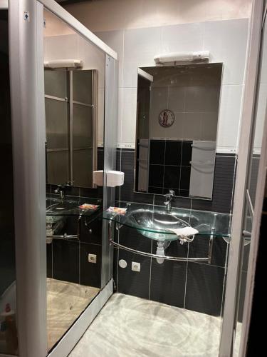 uma casa de banho com 2 lavatórios e um espelho em LAubergerie de Lastours em Coursan