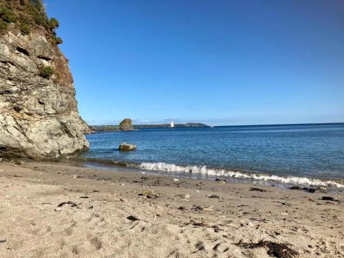 a sandy beach with a large body of water at Stunning Apartment, balconies, private beach, coast path in Charlestown