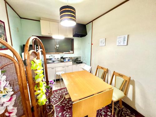 a kitchen with a table and chairs in a room at Shirahama in Miyazaki