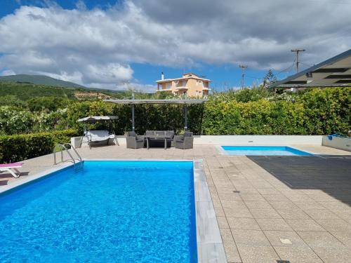 a swimming pool in front of a house at Friends and Family House in Petalidhion