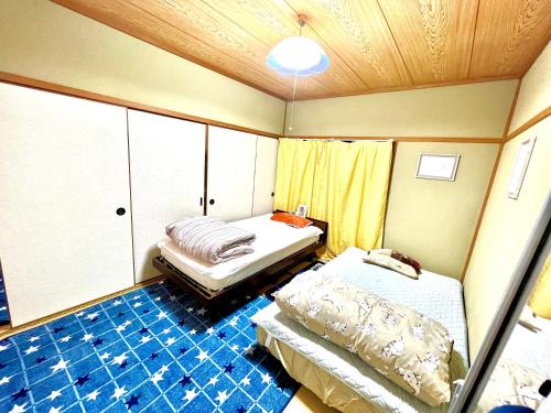 a room with two beds and a blue tile floor at Shirahama in Miyazaki