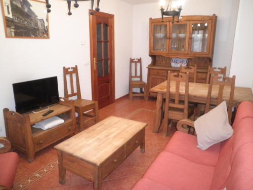 sala de estar con sofá y comedor en Apartamentos Anita, en La Alberca