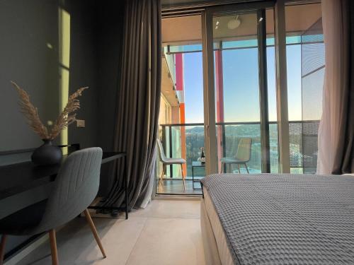 a bedroom with a bed and a view of a balcony at Ambassador Skyline Apartments in Tirana