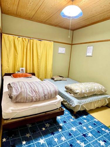 two beds in a room with yellow walls at Shirahama in Miyazaki