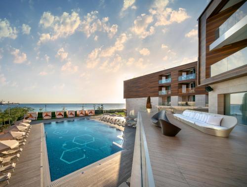 a house with a swimming pool on a deck with the ocean at Crowne Plaza Florya Istanbul by IHG in Istanbul