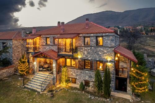 a large stone house with christmas lights on it at Ξενώνας Φωταξία in Palaios Agios Athanasios
