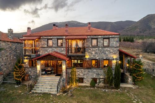 a large stone house with a red roof at Ξενώνας Φωταξία in Palaios Agios Athanasios
