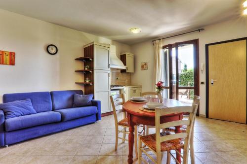 ein Wohnzimmer mit einem blauen Sofa und einem Tisch in der Unterkunft Alberese Casa Vacanze in Alberese