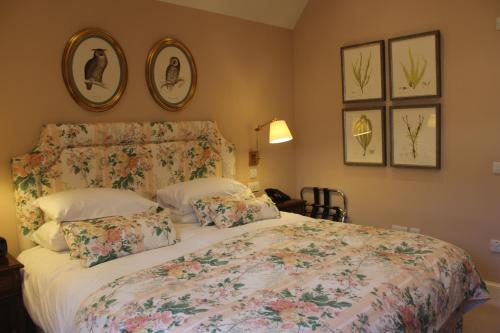 a bedroom with a bed with a floral bedspread and pillows at The Granary Lodge Bed & Breakfast in Thurso