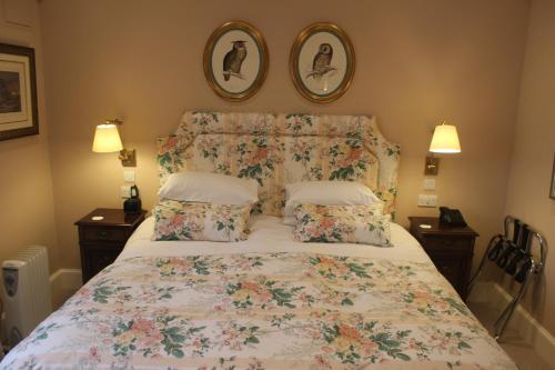 a bedroom with a bed with a floral bedspread and pillows at The Granary Lodge Bed & Breakfast in Thurso