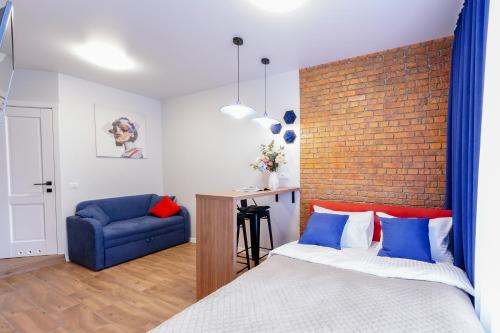 a bedroom with a bed and a blue chair at MYFREEDOM Апартаменти метро Сирець in Kyiv