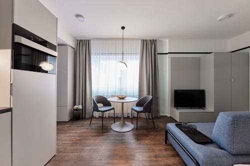 a living room with a couch and a table with chairs at The Amberlyn Suite Hotel in Budapest