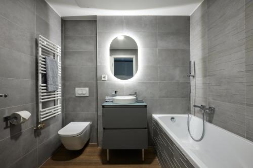 La salle de bains est pourvue d'un lavabo, d'une baignoire et de toilettes. dans l'établissement The Amberlyn Suite Hotel, à Budapest
