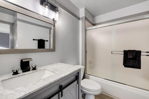 uma casa de banho com um lavatório, um WC e um espelho. em Monterey Dune Dream em Moss Landing
