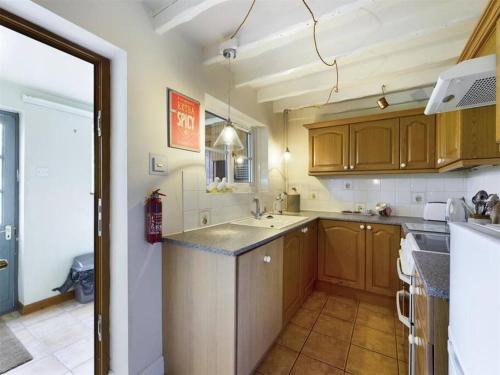 a kitchen with wooden cabinets and a counter top at Two Bedroom Cottage (rural setting with good Access links) in Grantham