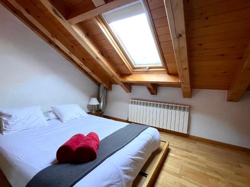 a bedroom with a bed with red pillows on it at Ca La Rougvie - L'Amfitriona in Esterri d'Àneu
