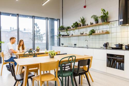 een man en vrouw aan een tafel in een keuken bij Tulum Apartament - Luxury & Top Design - Bath - Spodek - Free Parking in Katowice