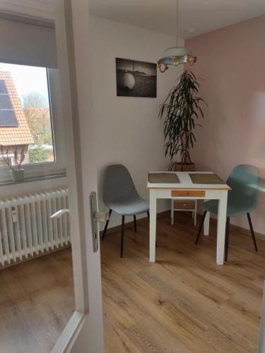 ein Esszimmer mit Tisch und Stühlen und einem Fenster in der Unterkunft Ferienwohnung Alte Schule Ruhwarden in Ruhwarden