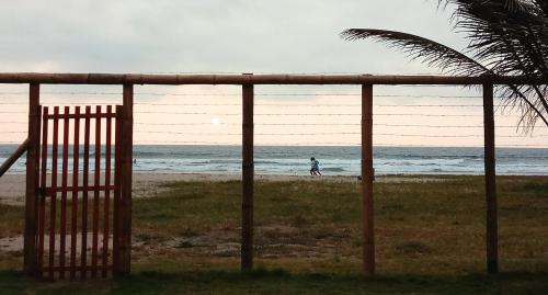 a person walking on the beach behind a fence at Portón Azul in Montañita