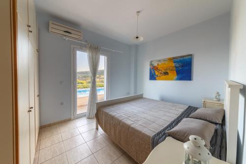 1 dormitorio con cama y ventana grande en Friends and Family House, en Petalidi