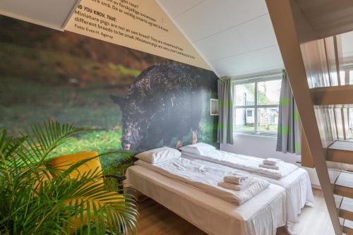 Namsskogan Familiepark & Hotell في Trones: غرفة نوم بسرير مع لوحة على الحائط