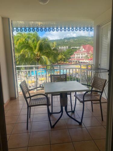 a table and chairs on a balcony with a view at Village Ste luce - Olivera Studio in Sainte-Luce