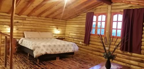 a bedroom with a bed in a log cabin at Rincón Lejano in Potrerillos