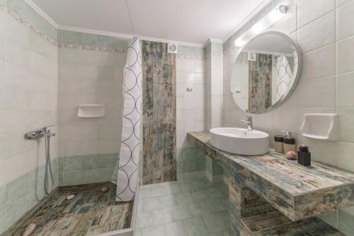 La salle de bains est pourvue d'un lavabo et d'un miroir. dans l'établissement Friends and Family House, à Petalidhion