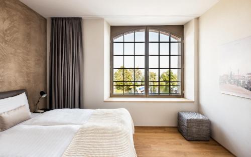 - une chambre avec un lit et une grande fenêtre dans l'établissement Appartements am See, à Romanshorn