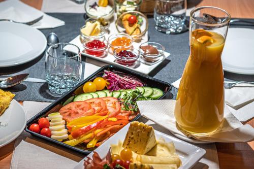 a table with a tray of food and a pitcher of juice at Hotel Tia Monte Nauders in Nauders