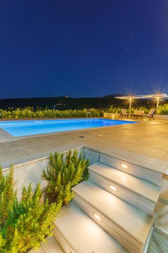 a villa with a swimming pool at night at Friends and Family House in Petalidhion