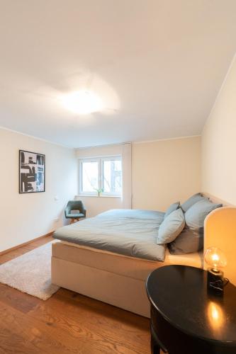 a bedroom with a large bed and a table at -Zentrale Wohnung-Balkon-Desingerküche- in Bielefeld