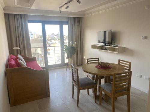 a kitchen and dining room with a table and a television at Departamento Completo Tandil in Tandil