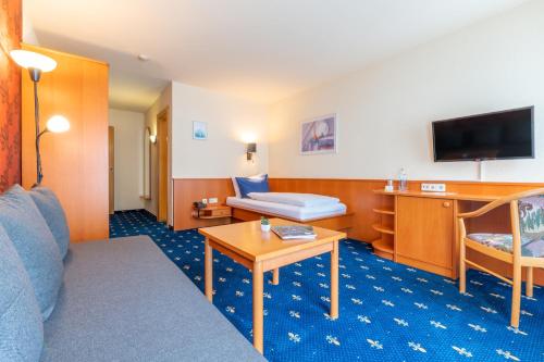 a hotel room with a couch and a table at Hotel Tia Monte Nauders in Nauders