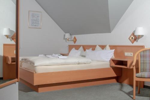 a bedroom with a bed with a desk and a chair at Hotel Kruse Zum Hollotal in Neuenkirchen-Vörden