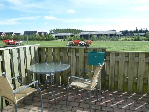 une table et des chaises sur une terrasse avec une clôture dans l'établissement Havrevang, à Billund