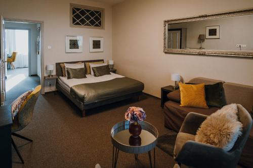 a bedroom with a bed and a couch and a table at Hotel Piano in Szeged