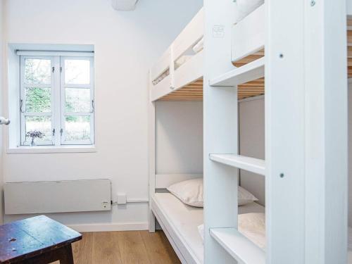 a small room with a bunk bed and a window at Holiday home Allingåbro XXIV in Allingåbro