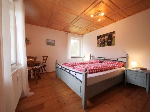 1 dormitorio con 1 cama con edredón rojo en Ferienwohnung Böck, Wengen im Allgäu en Weitnau