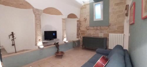 un soggiorno con un divano blu e una TV di Palazzo Saraceno apartments-Antica mangiatoia a Taranto