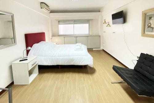 1 dormitorio con 1 cama blanca y 1 silla en CORD0304 Hermoso y super cómodo Depto entero en el Centro en Buenos Aires