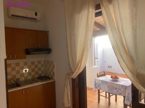 une cuisine avec une table et une table ainsi qu'une fenêtre dans l'établissement Stella del Mattino, à Lipari