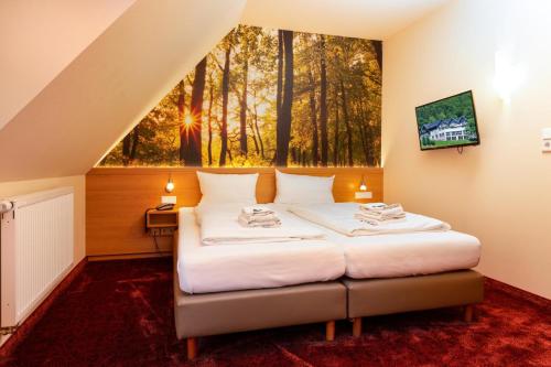 a bedroom with a bed with a large window at Waldhotel Schinkenwirt in Olsberg